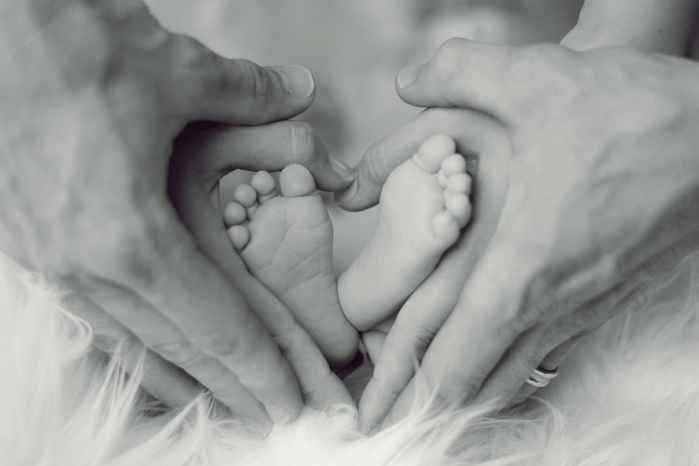 Réflexologie bébé : pieds tenus dans les mains d'Estelle